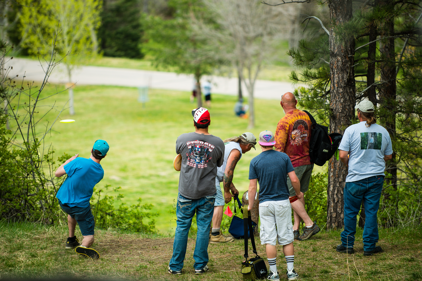 A group tees off toward hole 17, one of the fairways at Chadron State Park featuring a drop in elevation.