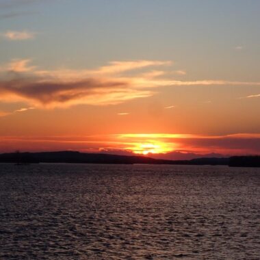 A sun sets over a lake in Nebraska during spring.