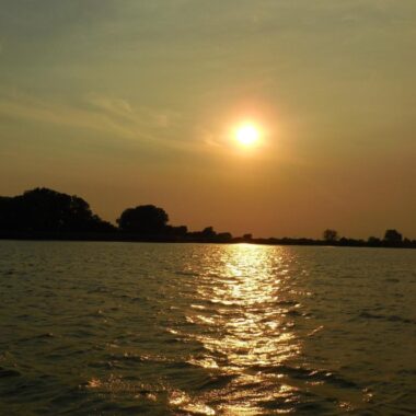 Sun low in sky over a Nebraska reservoir.