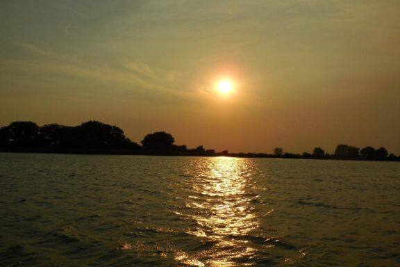 Sun low in sky over a Nebraska reservoir.