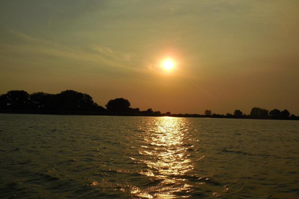 Sun low in sky over a Nebraska reservoir.