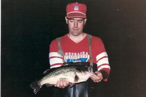 Angler holding a largemouth bass.