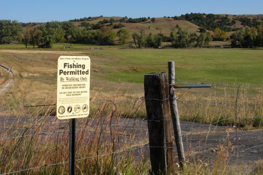Open waters sign on fence line.