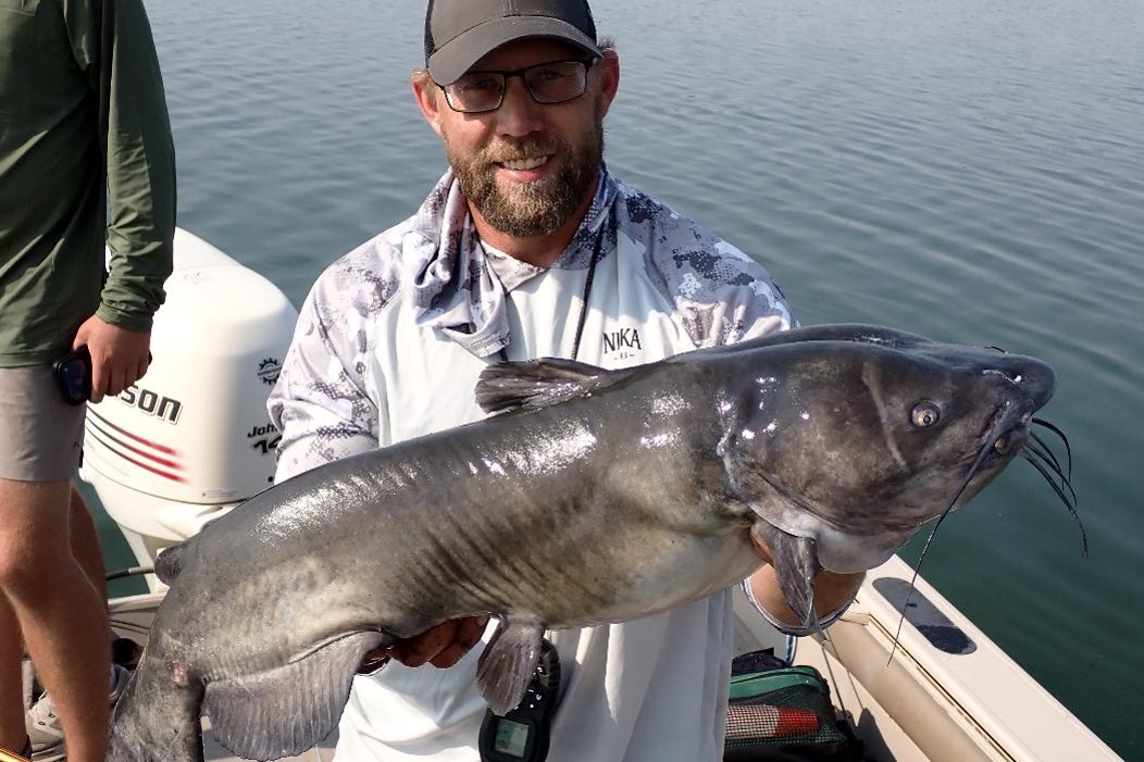Angler holding large channel catfish. 