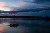 Anglers fish from a boat in the Nebraska Sandhills during summer as the sun sets.