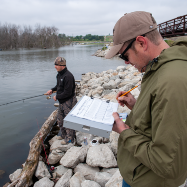 A man surveys an angler during a creel survey in Nebraska.