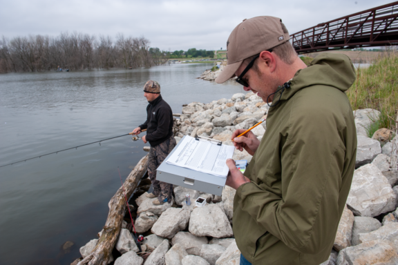 A man surveys an angler during a creel survey in Nebraska.
