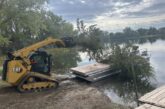 Cut cedar trees being placed on barge at Bridgeport SRA. Photo by Nebraska Game & Parks Commission.