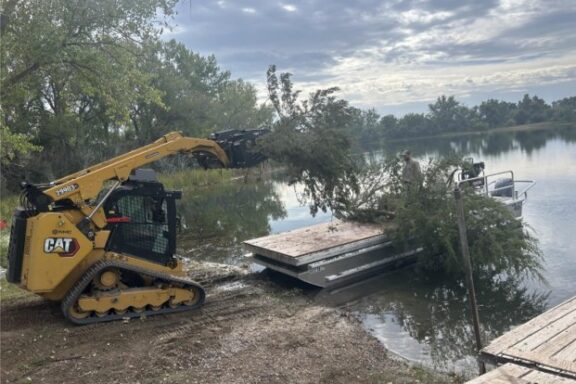 Cut cedar trees being placed on barge at Bridgeport SRA. Photo by Nebraska Game & Parks Commission.
