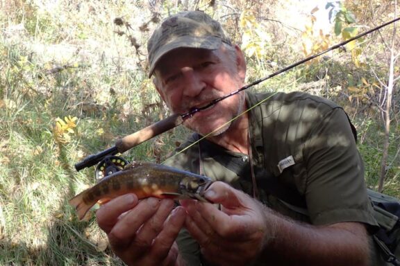 Angler holding brook trout caught on fly rod. Photo by Daryl Bauer, Nebraska Game & Parks Commission.